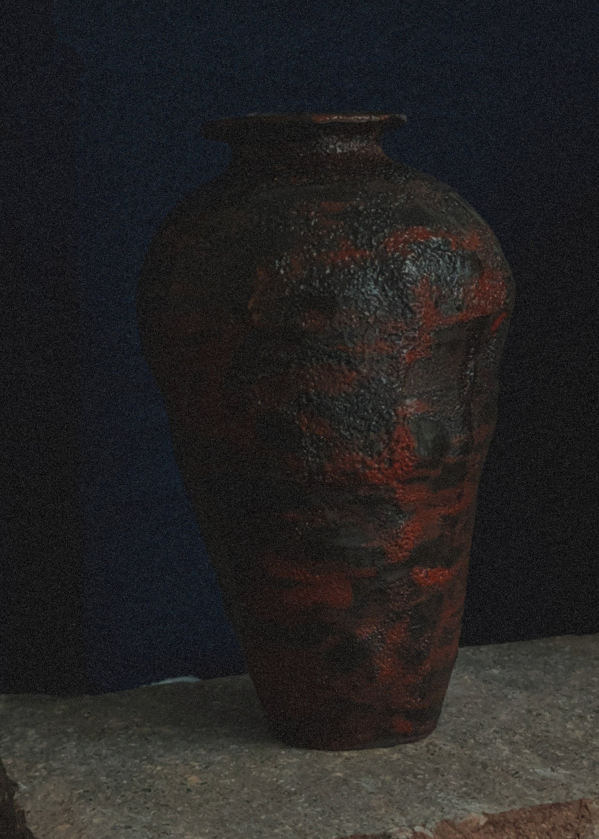 Decorative vase with red and black patterns on a dark background