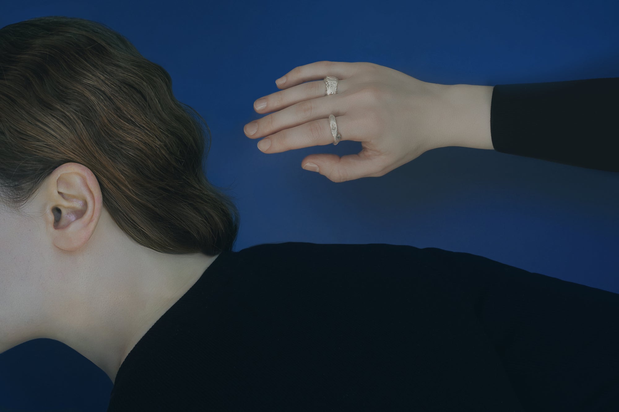 Person wearing a black shirt with a blue background